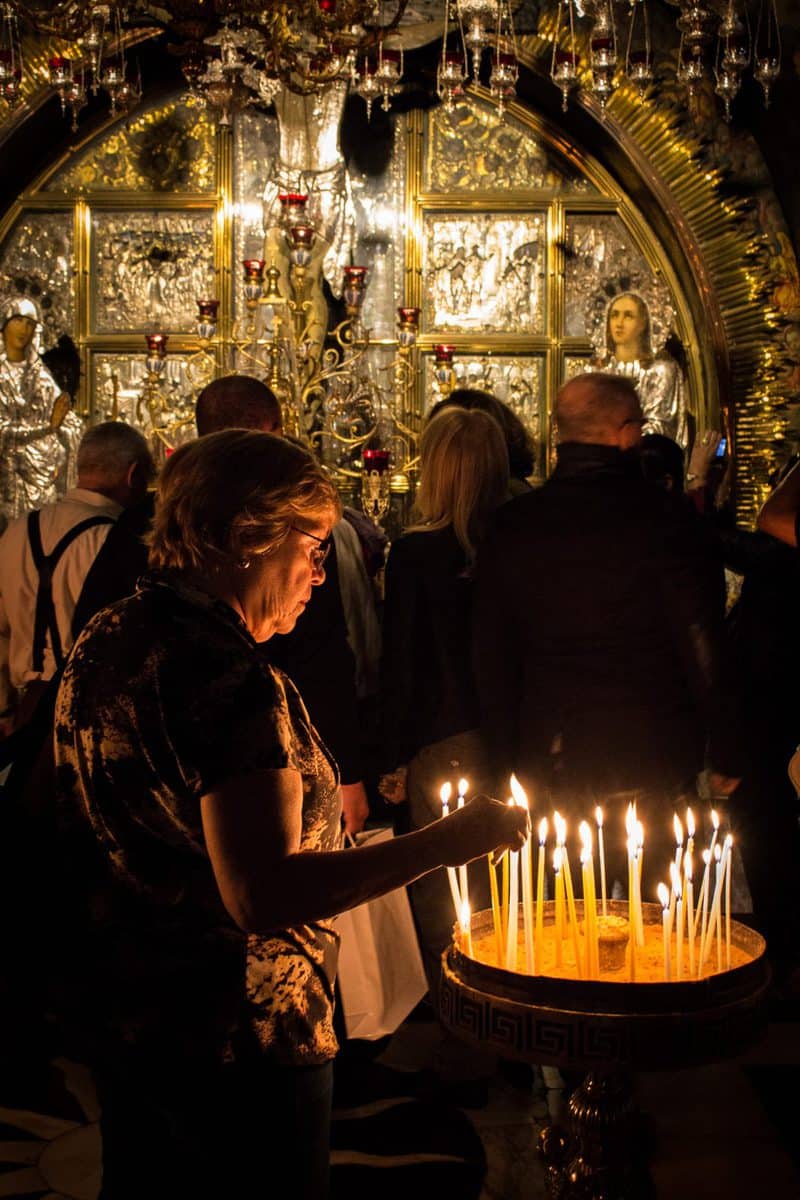 Lighting a candle inside the Church of the Holy Sepulchre