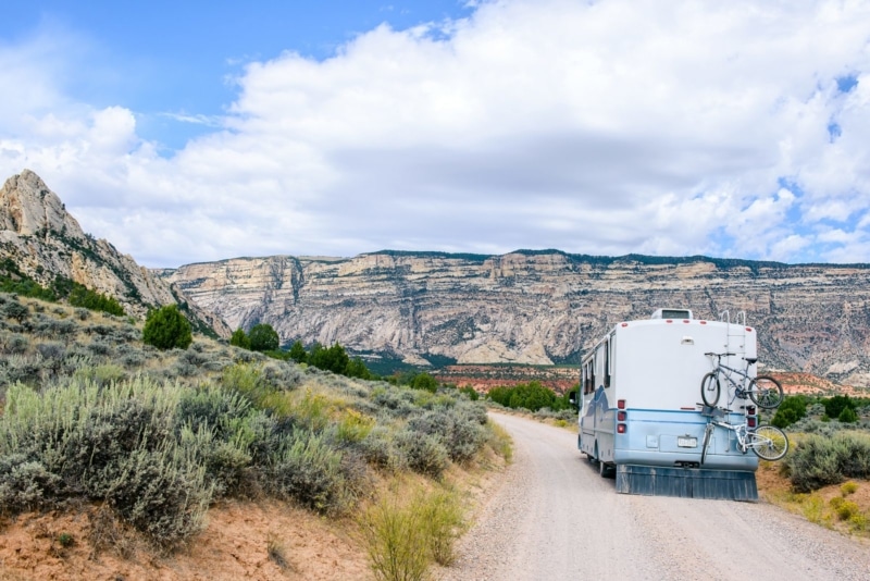 A full-sized RV rental driving through a canyon