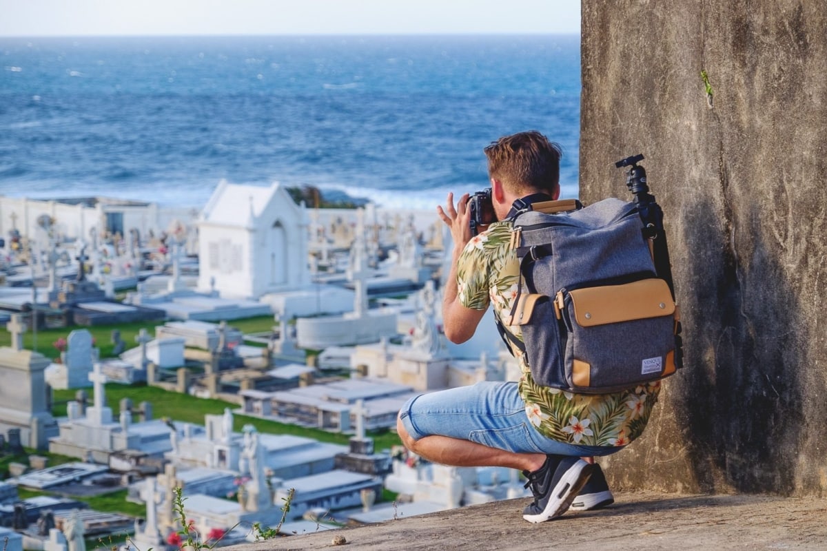Man wearing a backpack and photographing the ocean in Puerto Rico