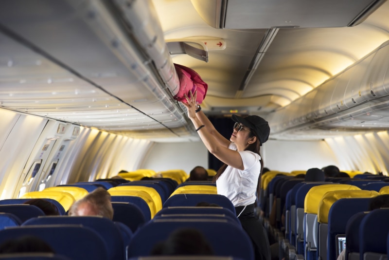 Traveler opens overhead locker on airplane