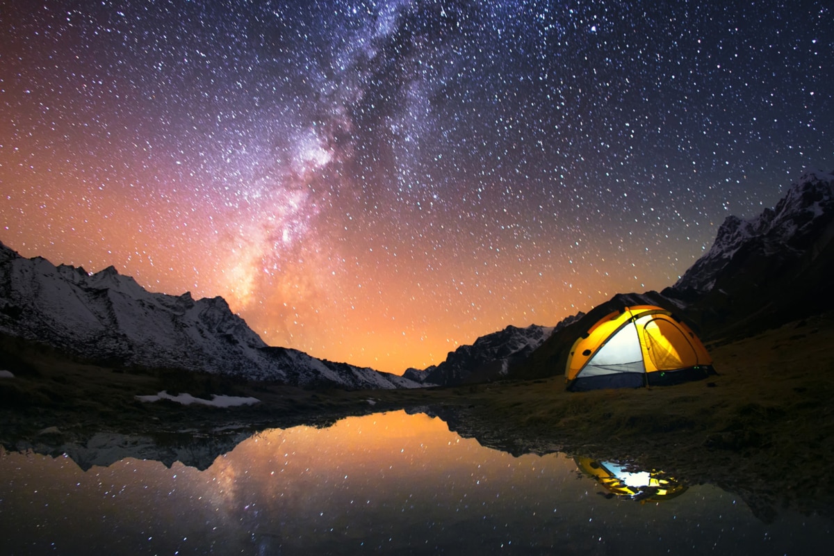 View of starts and tent at night at a lake.