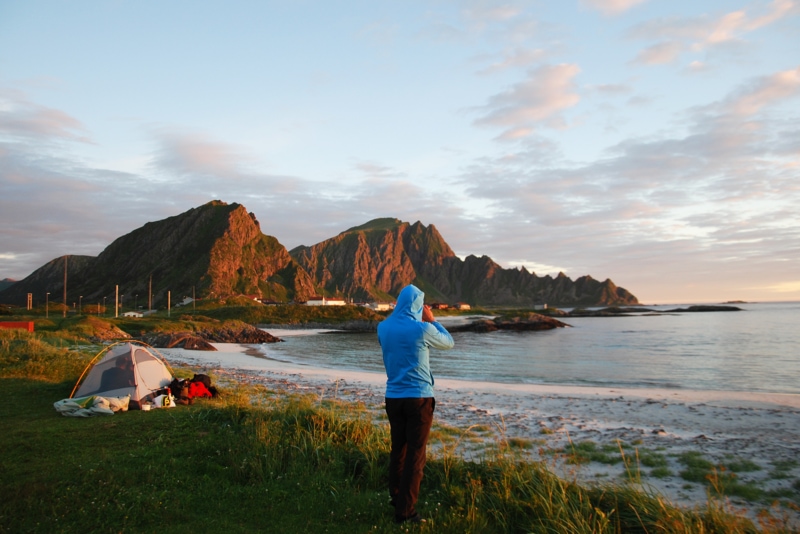 a man sets up his campsite by the ocean