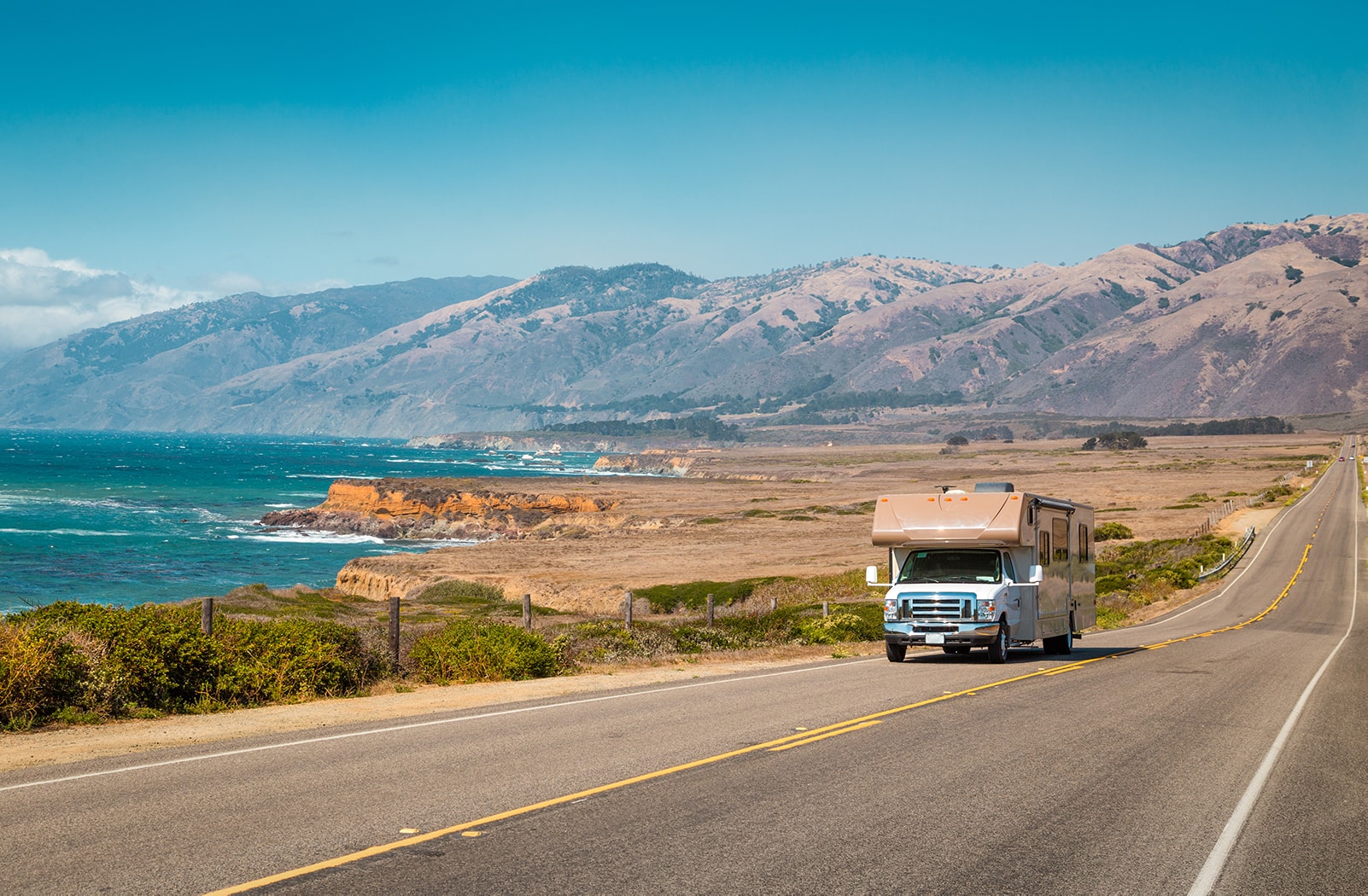 A large RV drives along the California Highway 1