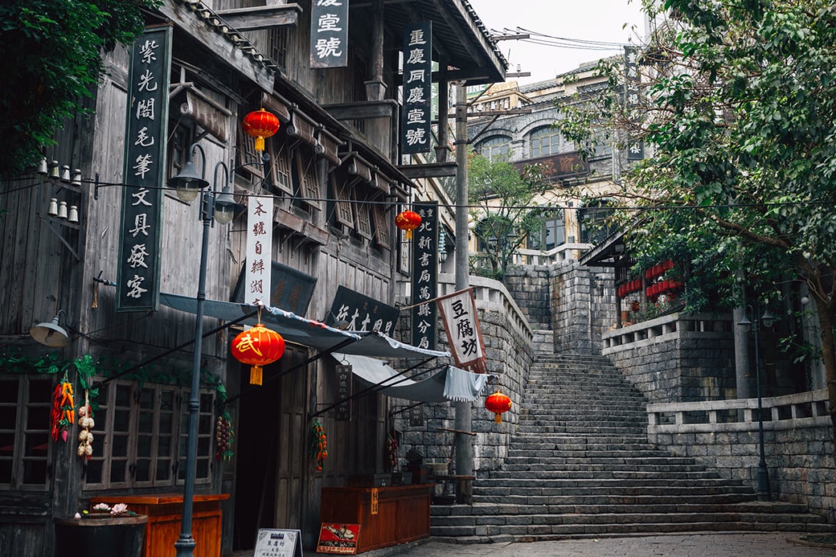 Orange lanterns and a tall staircase in a Chinese alleyway