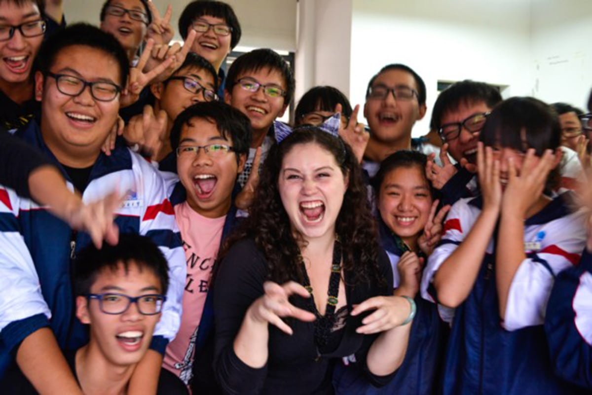 Richelle Gamlam posing with students in China