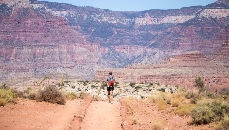 a man running through a red canyon