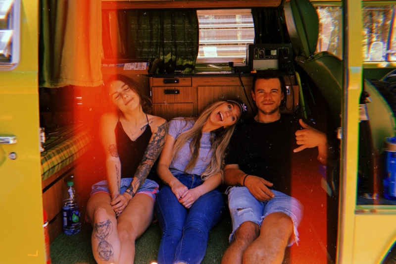 Friends hanging out in the back of a campervan