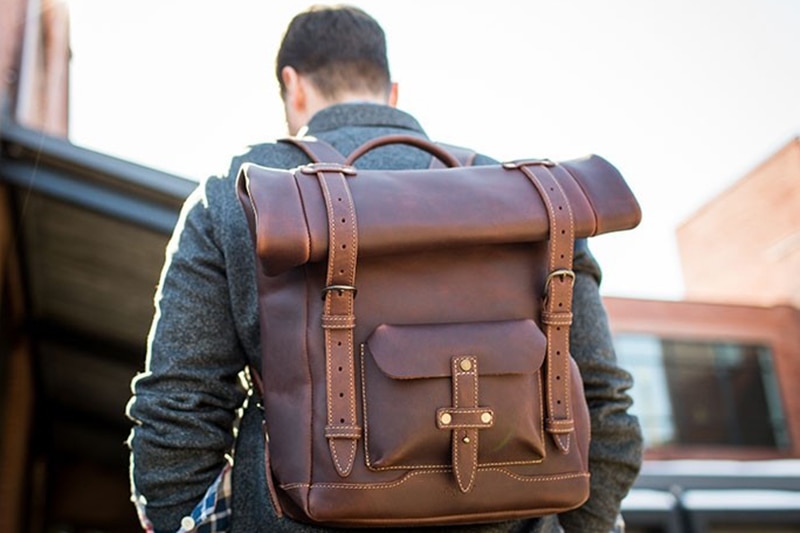 man wearing a brown Pad & Quill Heritage Rolltop leather backpack