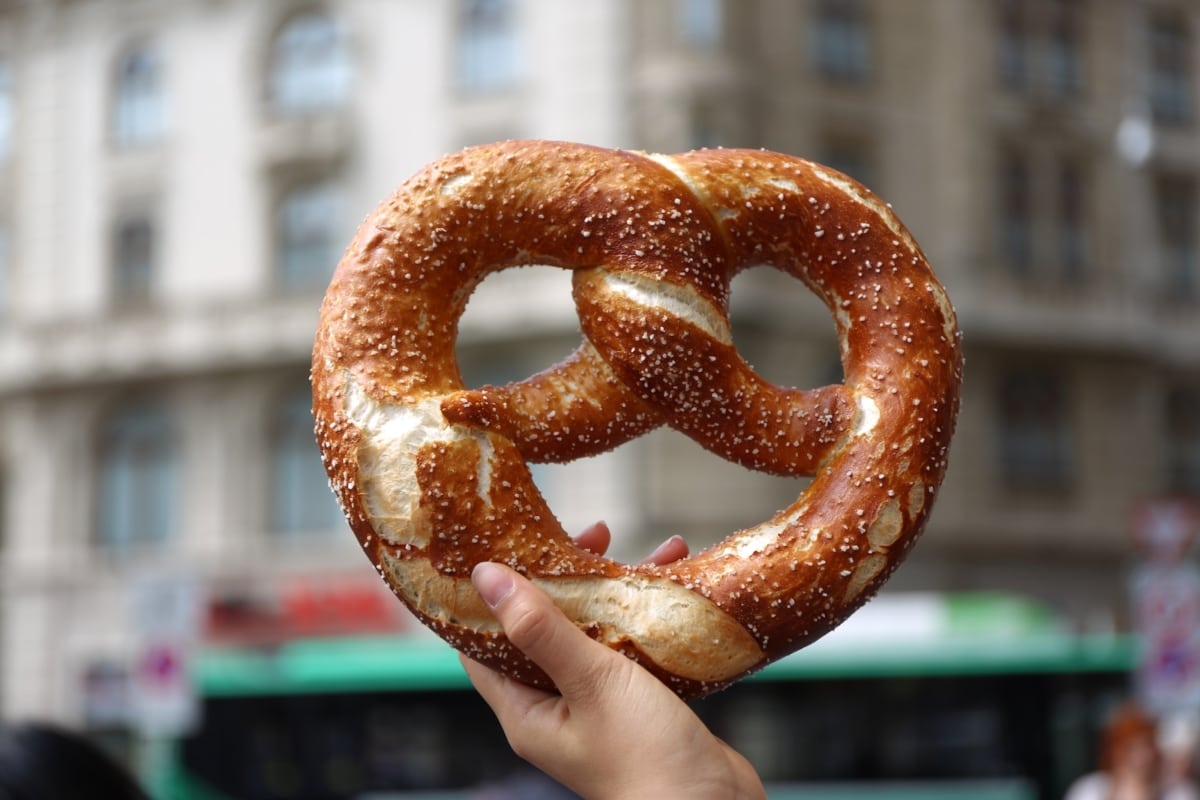 a woman holding a giant pretzel in Germany
