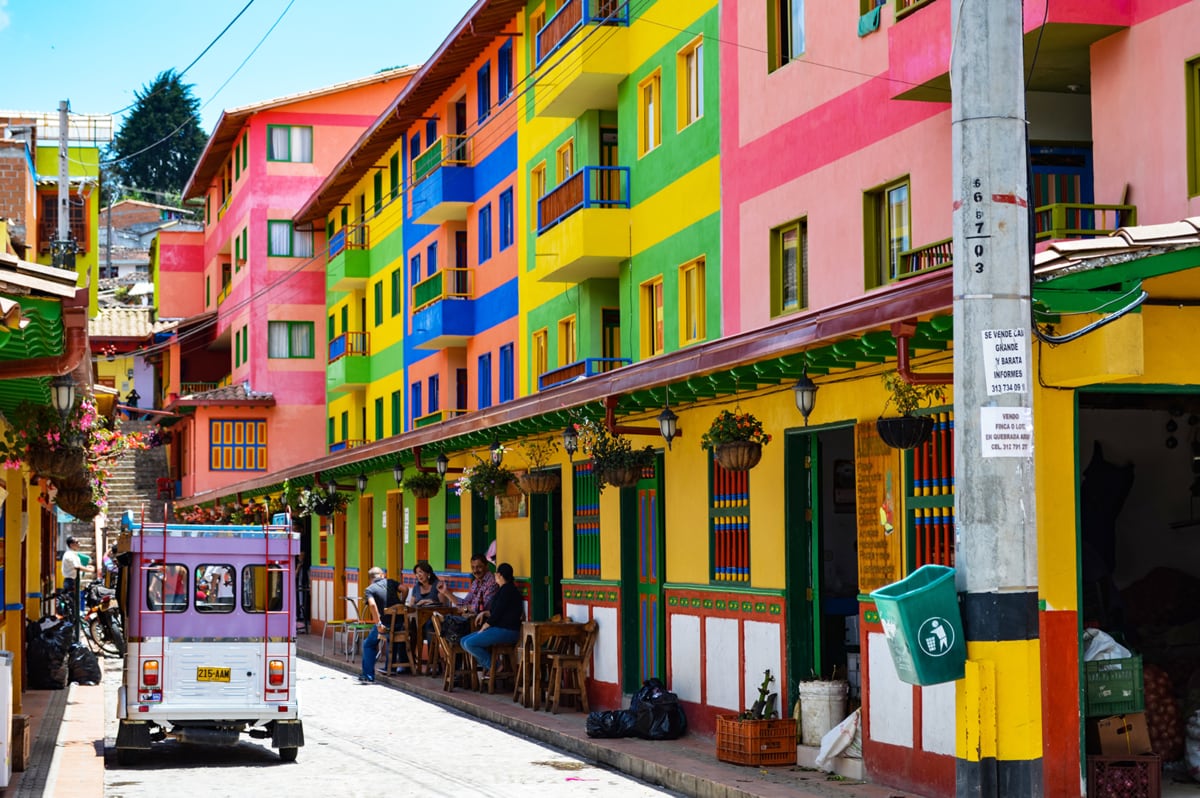 Brightly painted buildings on a Colombian street with a tuk-tuk