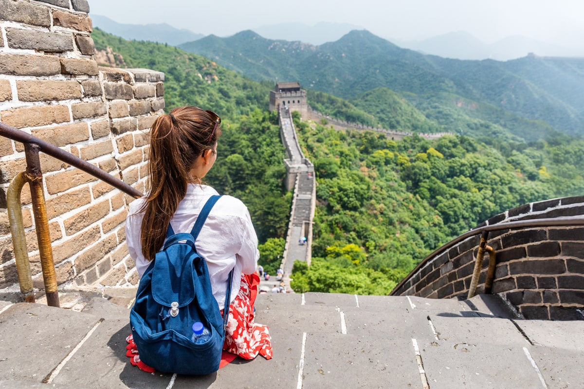 A girl sitting on the Great Wall of China