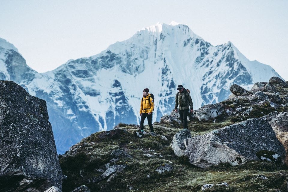 Two people hiking in the mountains wearing Mountain Hardwear Clothing
