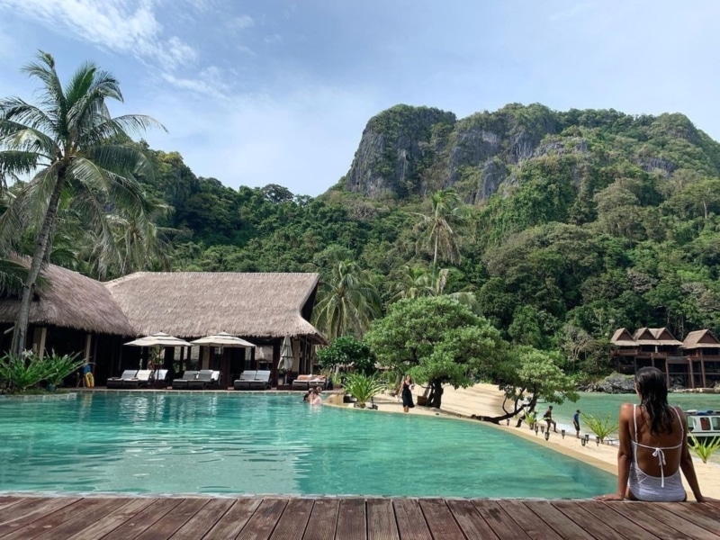 a woman sitting on a pool on an island resort