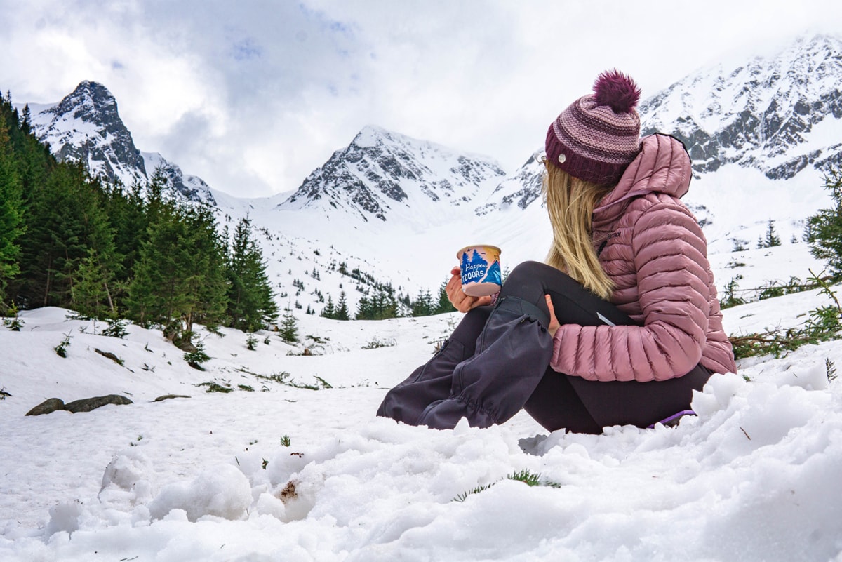 woman in the snow wearing a Marmot jacket